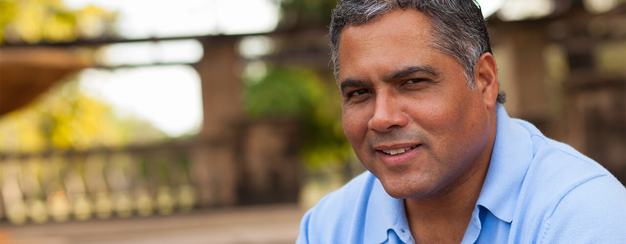 A man smiling, looking directly into the camera.